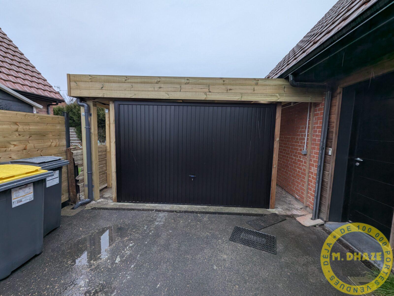 Vue extérieure d'un porte de garage basculante noire de marque Novoferm posée sur carport existant en bois à Neuville en Ferrain (Nord) .jpg
