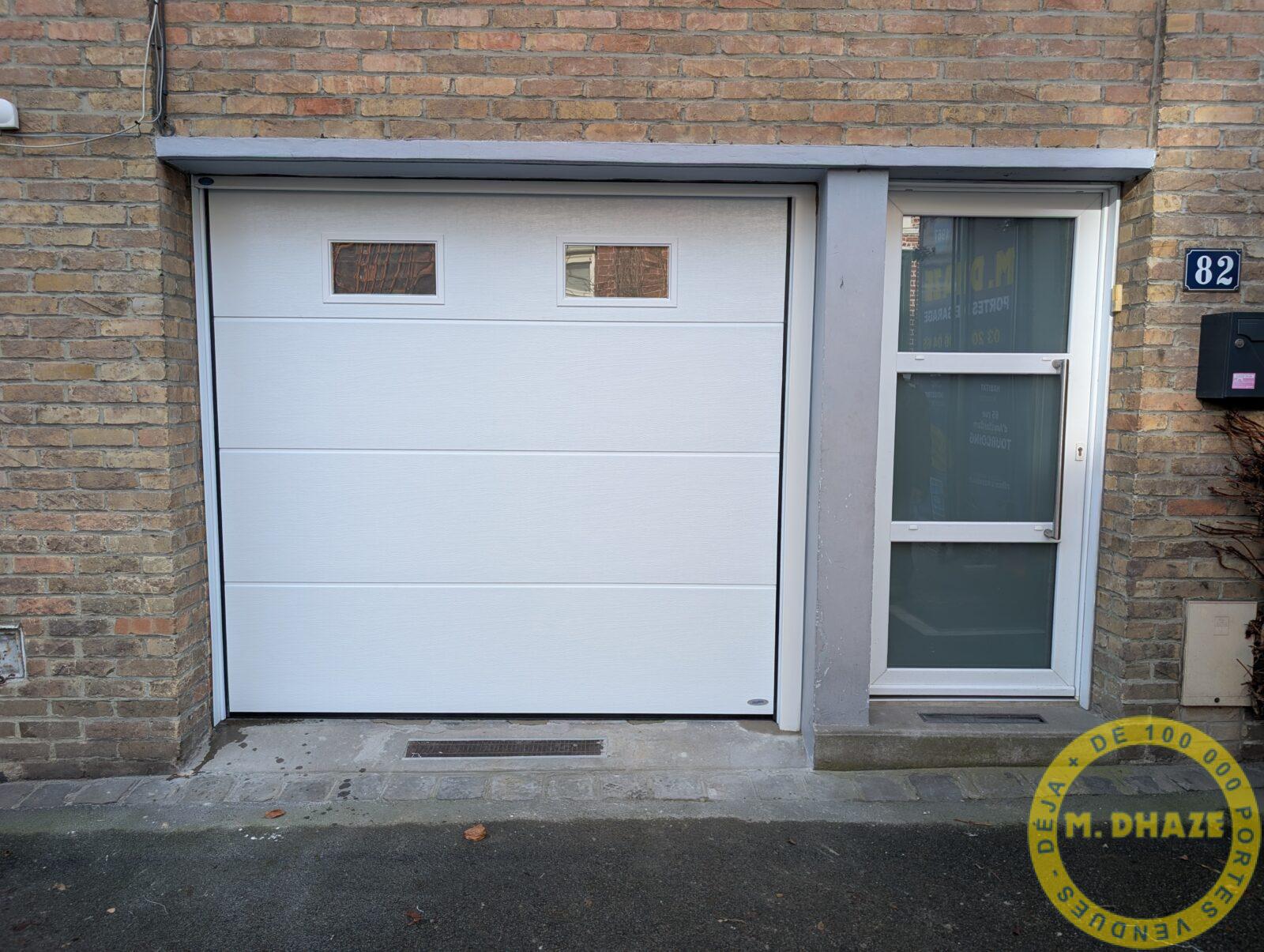 Remplacement d'une porte de garage a déplacement latéral par une porte de garage sectionnelle blanche de marque Novoferm. Le tout réalisa à Roubaix (Nord)